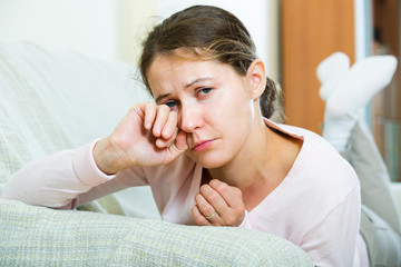 Sad young woman at home.