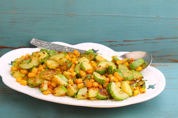 a side dish of zucchini with corn and cheese