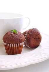 chocolate cupcakes with a cup of tea on a white plate, white background