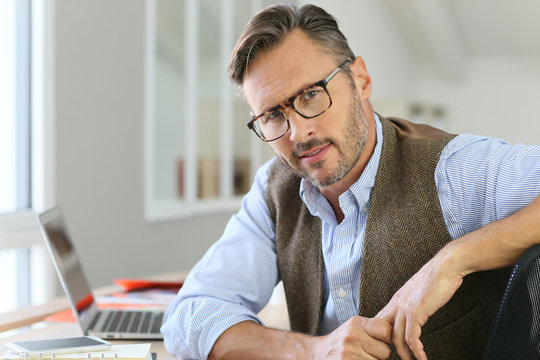 Handsome man with eyeglasses sitting in office