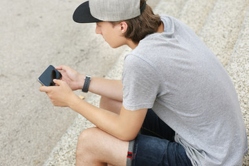 Teenage boy typing text message.Using smart phone