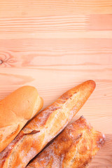 Freshly baked baguette and bread on wooden background
