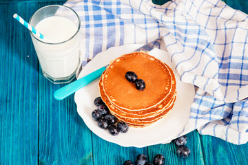 
hearty and healthy breakfast , American pancakes with milk and dark grapes on a wooden background
