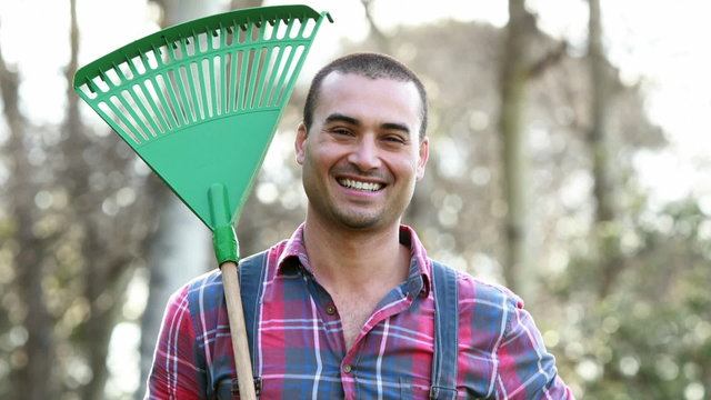 Happy farmer holding rake