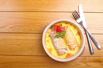 rolled pancakes on a plate with honey and powdered sugar