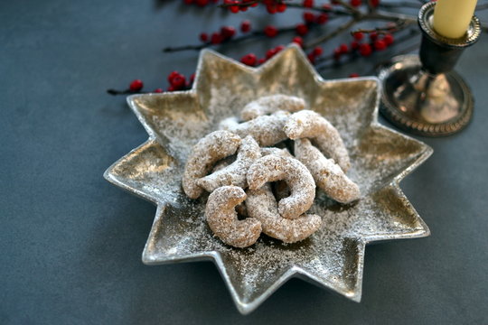 German Kipferl Cookies dusted with icing sugar on a star shaped plate against a grey background 3