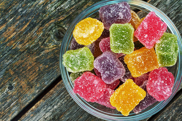 Fruit jellies on a plate on a wooden background