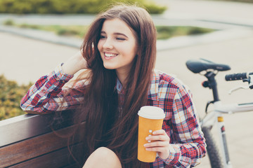 Young woman drinking coffee on a bicycle trip