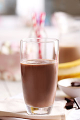 Glass of chocolate milk on table close-up