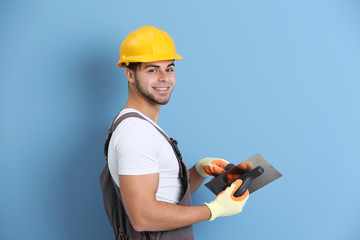 Young worker renewing apartment on wall background