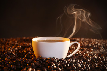 Cup of hot coffee and coffee beans closeup