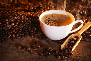 Cup of coffee and coffee beans on table