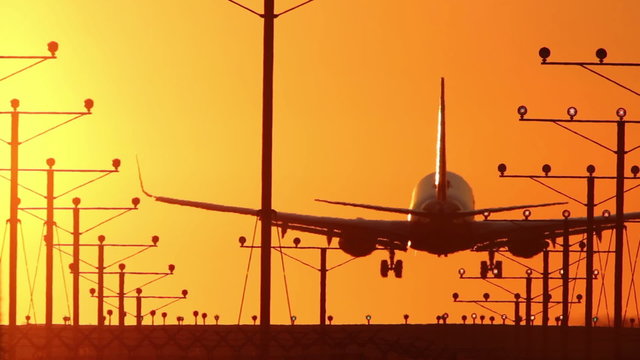 HD clip of a narrow body twin engine jet coming in for a landing during sunset