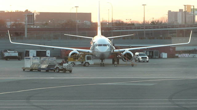 HD clip of a twin engine commercial jet plane being servied on the tarmac.