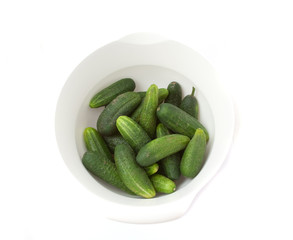 fresh cucumbers in the bowl on a white background.ïîèñê