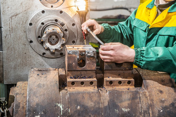 Factory worker measure detail with digital caliper micrometer du