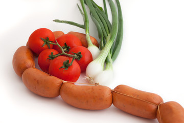 Fresh raw vegetables and sausage on a white background