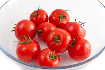 tomatoes in a glass bowl on a white background
