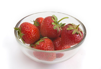 strawberries in a glass bowl on a white background