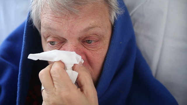 a senior man suffering from chills, runny nose and other flu symptoms
