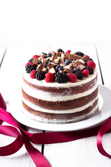 Layer cake on white wooden table.