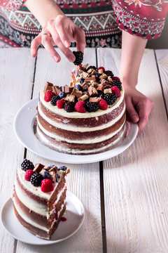 Layer Cake On White Wooden Table And One Slice On Saucer.