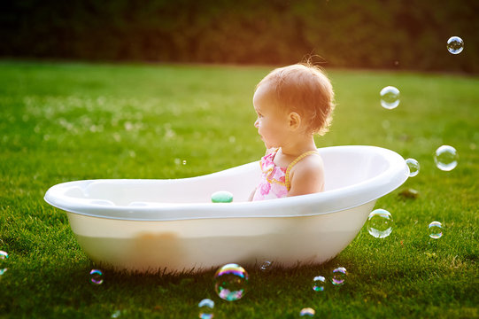beautiful little girl bathes in summer