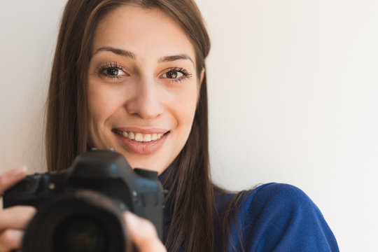 Brunette smiling woman photographer taking pictures with camera