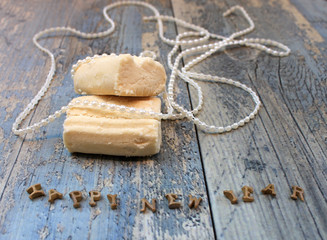 New Year composition shortbread biscuit and white pearl beads on a wooden table