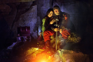 Old medieval King with princess are sitting on furs