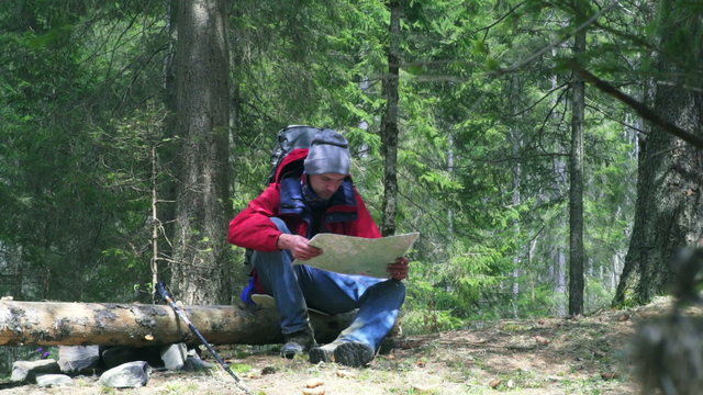 hiker watching the map in forest