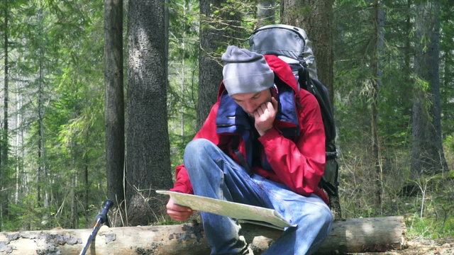 hiker viewing the map in forest