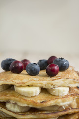 pancakes with banana, honey and blueberries for breakfast on a t