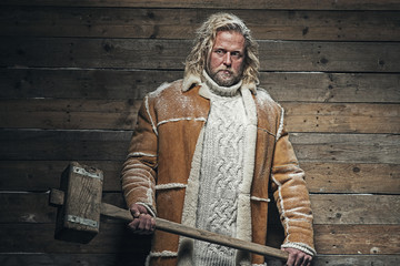 Fototapeta na wymiar Lumberjack Winter Fashion Man Long Blonde Hair and Beard. Holdin