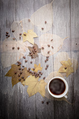 cup of coffee and coffee bean and dry leaves on Wooden Table