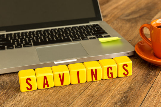 Savings written on a wooden cube in a office desk