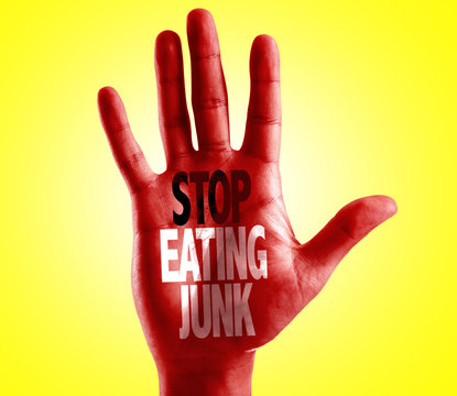 Stop Eating Junk written on hand with yellow background