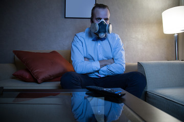 Man in respirator watching TV