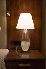 A lamp on a bedside cabinet