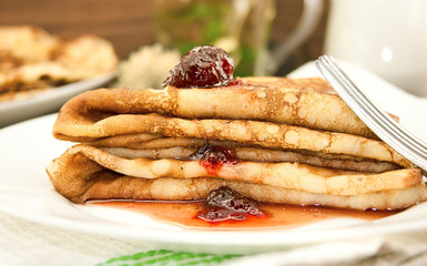 Sweet dessert of pancakes on a plate with strawberry jam. Breakf