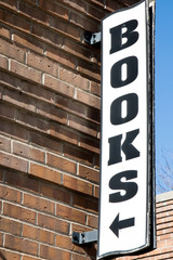 Sign for BOOKS on a brick building with arrow