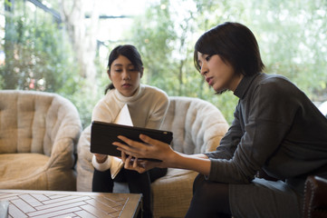 Fototapeta premium Women are talking while showing a tablet