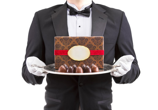 Waiter Holding Silver Platter With Chocolate