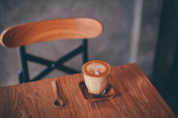 cup of coffee latte on the wood texture   in vintage color tone