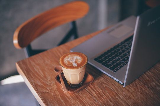 cup of coffee latte on the wood texture   in vintage color tone