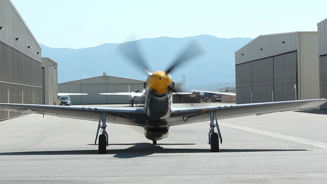 A World War II vintage North American P-51 Mustang fighter starts its engines