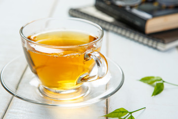 Tea and book on white wooden background