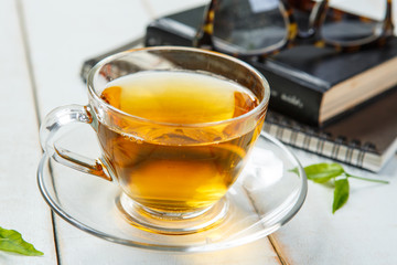 Cup of tea and book on white wooden table