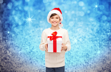 smiling happy boy in santa hat with gift box