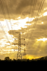 Sun setting behind the silhouette of electricity pylons - Vibran